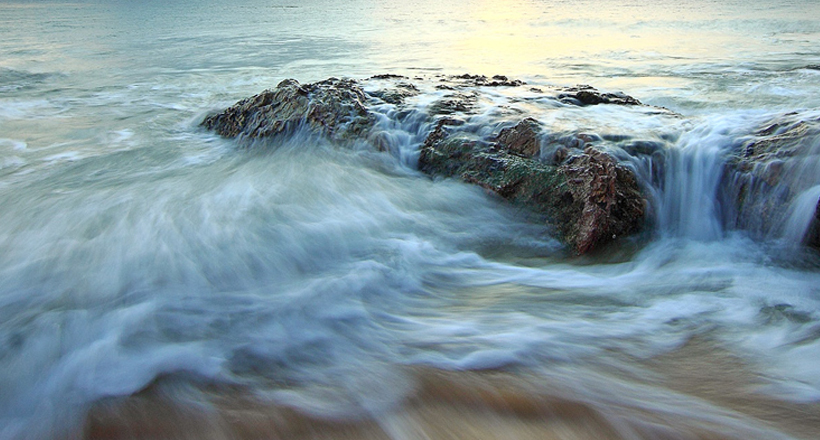 ocean waves crash on rocks